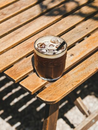 A glass of refreshing iced coffee on a terrace – summer coffee drinks from Coffee People