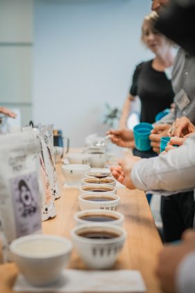 People participating in a coffee cupping session, tasting different coffees and evaluating their flavor profiles.