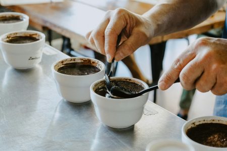 Inimene segab cupping’u käigus kohvitassides kohvipuru - kohvi degusteerimise oluline samm, kus avanevad joogiaroomid.