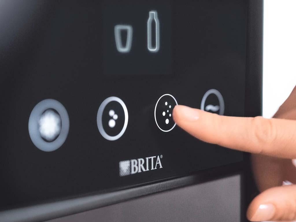 Sõrm puudutab Brita veefiltri seadme juhtpaneeli. puhta ja kvaliteetse vee valik kohvi valmistamiseks