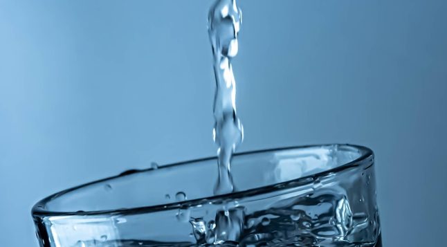 Brita veefilter. Filtreeritud vesi voolab klaasi. puhas vesi kohvi valmistamiseks.